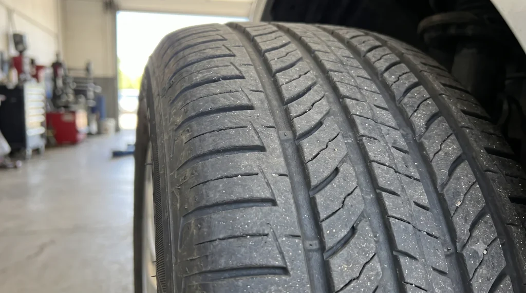 a car tire tread showing the wear indicator (TWI) clearly